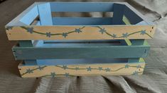 a wooden crate with blue flowers painted on it's sides and the bottom section is made out of wood