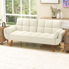 a white couch sitting on top of a hard wood floor next to a wooden table