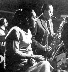 an old black and white photo of two people playing instruments