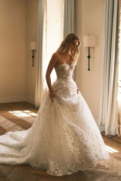 a woman in a wedding dress standing on the floor