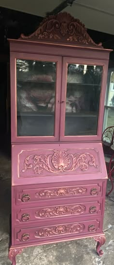 an old dresser painted pink with ornate carvings on the front and sides, sitting in a garage