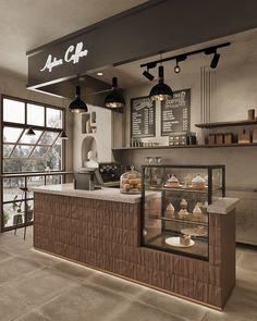 the interior of a coffee shop with lots of counter space and lights hanging from the ceiling