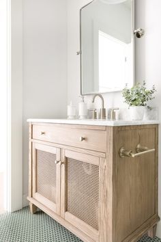 a bathroom with a sink, mirror and tiled floor