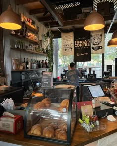 a coffee shop filled with lots of pastries and drinks on top of a wooden counter