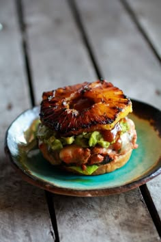 a pineapple burger with lettuce and other toppings sits on a plate