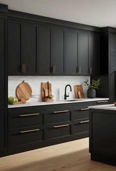 a kitchen with black cabinets and wooden cutting boards on the counter top, along with an island