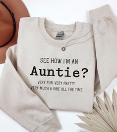 Welcome to our cozy corner of Etsy, where style meets sass with a touch of sweetness! Our Demure but Funny Auntie Sweatshirt is the perfect blend of elegance and humor--just like your favorite auntie. Crafted for those who cherish subtle sophistication with a wink of wit, this sweatshirt is a must-have for any aunt who knows how to keep it classy while sharing a laugh. .: Made with a medium-heavy fabric blend of 50% cotton and 50% polyester (8.0 oz/yd² (271.25 g/m this sweatshirt feels cozy and is the perfect choice for those colder months. .: The classic fit along with the crew neckline deliver a comfy wearing experience with a clean-cut style. Meanwhile, the double-needle stitching at the shoulder, armhole, neck, waistband, and cuff seams add top-tier durability.  .: Say goodbye to itchi Auntie Sweatshirt Ideas, Aunt Outfits, Auntie Sweatshirt, Gifts For Aunts, Auntie Life, Christmas Gifts For Aunts, Aunt Life, Gift For Aunt, New Aunt