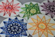 four circular coasters with different colored designs on the top one has a star in the middle