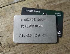 two credit cards sitting next to each other on a wooden table with the words, a decade down forever to go