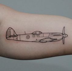 a small airplane tattoo on the arm