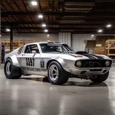 an old race car is parked in a garage