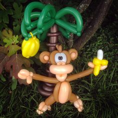 an inflatable monkey holding two yellow balloons