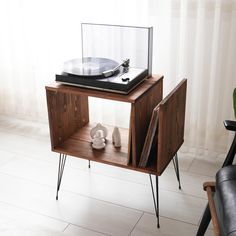 an old record player is sitting on top of a wooden cabinet with hairpin legs