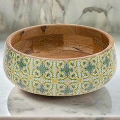 a wooden bowl sitting on top of a marble counter