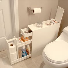 a white toilet sitting in a bathroom next to a roll of toilet paper and a trash can