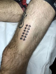 a man's leg with a cross tattoo on his left arm and the word love written in black ink