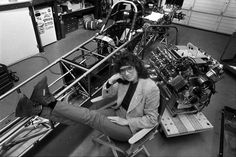 a man sitting on top of a chair in front of a machine shop filled with machines