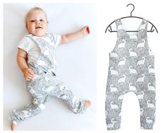 a baby laying on top of a white wall next to an infant's pajamas