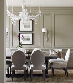 a dining room table with white chairs and chandelier