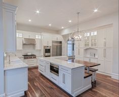 a large kitchen with white cabinets and an island