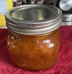 a glass jar filled with food sitting on top of a red tablecloth covered floor