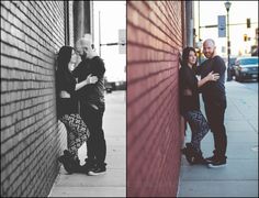 two people standing next to each other near a brick wall and one person leaning against the wall