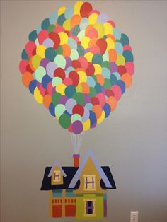 a house with a bunch of balloons in the shape of houses on top of it