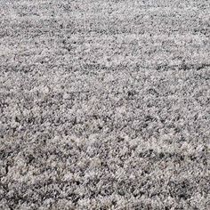 an area rug is shown in grey and white colors, with small patches of black on the carpet