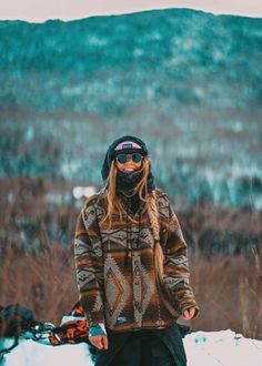 a woman standing in the snow wearing skis