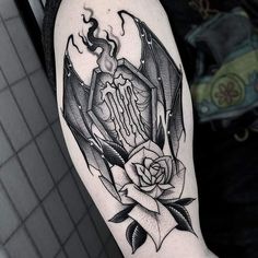 a black and white tattoo with a rose on it