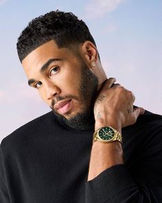 a close up of a person with a watch on his wrist and wearing a black shirt