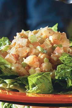 a plate with lettuce and shrimp salad on it