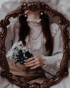 a woman with long hair holding flowers in front of a mirror