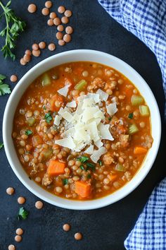 a white bowl filled with lentula, carrots and parmesan cheese