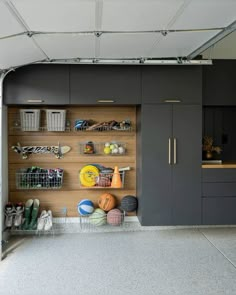 a garage with gray cabinets and shelves filled with items