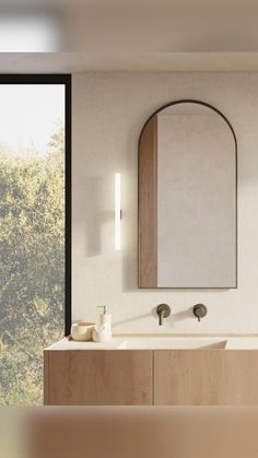 a bathroom with a sink, mirror and large window in it's side wall