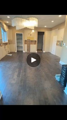 an empty living room with wood floors and chandelier