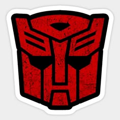 a red and black sticker with the shape of a transformer head on it