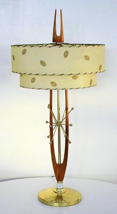 a lamp that is sitting on top of a white table with a light shade over it