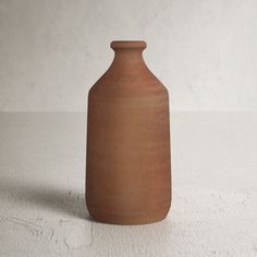 a brown vase sitting on top of a white table