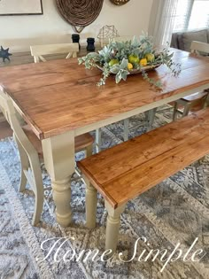 a dining room table with two benches and a bowl of flowers on top of it