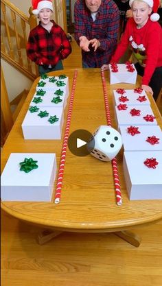 three children and an adult standing at a table with christmas decorations on it, including candy canes