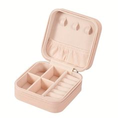 an open pink jewelry box with compartments on the bottom and inside, sitting on a white surface