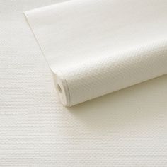 a roll of white fabric sitting on top of a table