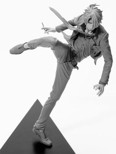 an action figure is posed on top of a triangular object with one leg in the air