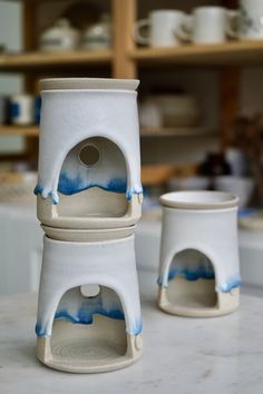 two white cups sitting on top of a counter