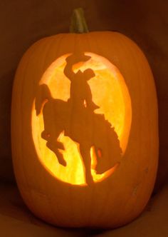 a carved pumpkin with a horse and rider on it