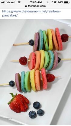 a white plate topped with fruit and veggies on skewers