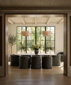 the dining room table is surrounded by black chairs and round tables with lamps on them