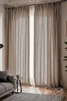 a living room with white curtains and a gray couch